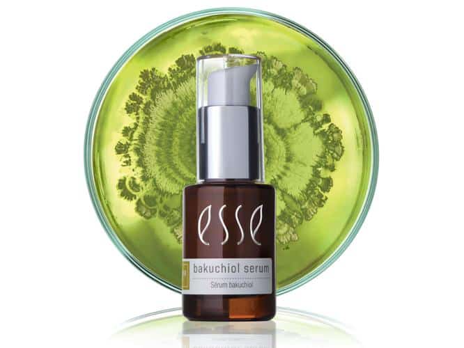 A bottle of Esse Bakuchiol Serum with a white pump top is shown in front of a green, circular, botanical-patterned background.