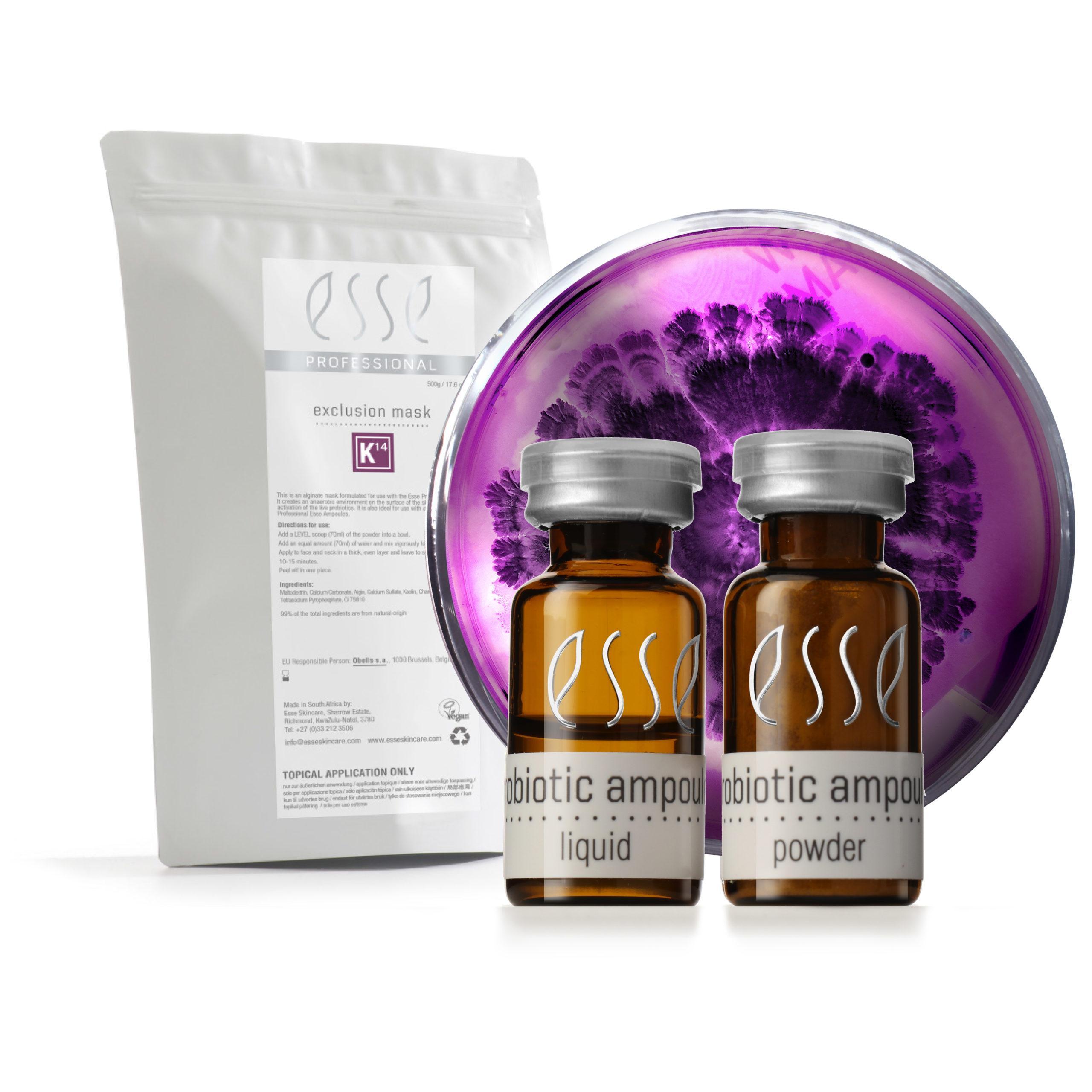 A white packet, two small brown bottles labeled "probiotic ampoule" (liquid and powder), and a round dish with a purple bacterial culture, arranged on a white background.